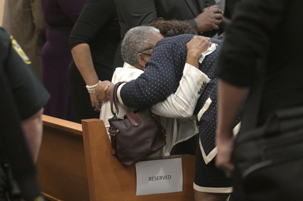 Carol Greenlee Crawley, center, daughter of Charles Greenlee, is comforted by Beverly Robinson, cousin of Samuel Shepherd, after Circuit Court Judge Heidi Davis dismissed all charges against Ernest Thomas, Samuel Shepherd, Charles Greenlee and Walter Irvin, known as the Groveland Four, during a proceeding at the Lake County Courthouse Monday, Nov. 22, 2021, in Tavares, Fla. The four were falsely accused of raping 17-year-old Norma Padgett and assaulting her husband in 1949. (Phelan M. Ebenhack for the Orlando Sentinel)