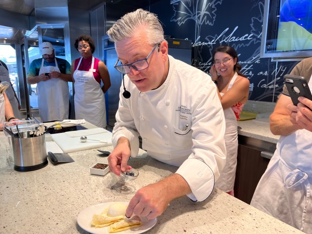 Chef John Stephano shows his class aboard 'Grandeur' how to plate the crepes they will make.