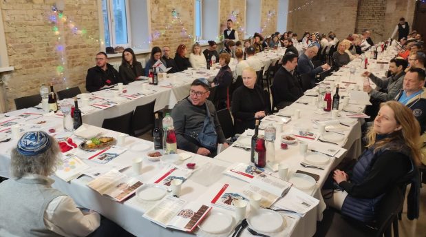 Guests at a Seder in Kyiv, Ukraine, including many families from heavily damaged Kharkiv, sit around the table on the first night of Passover in 2023. (Michael Gascon Barbera/Courtesy)