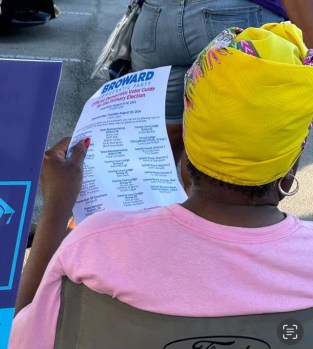 A Broward voter studies a slate card distributed by the local Democratic party.