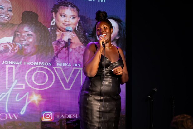 A female comedian performs on a stage