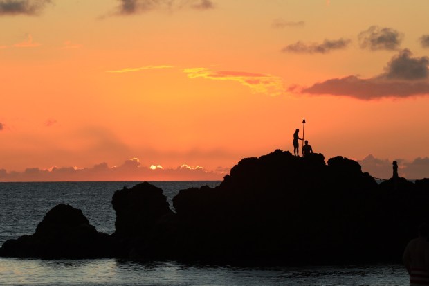 At sunset on Ka'anapali Beach, guests at the Sheraton Maui Resort and Spa gather to watch the spectacular nightly torch-lighting and cliff dive ceremony at the promontory called Pu'u Kekaa. (Ben Davidson Photography)