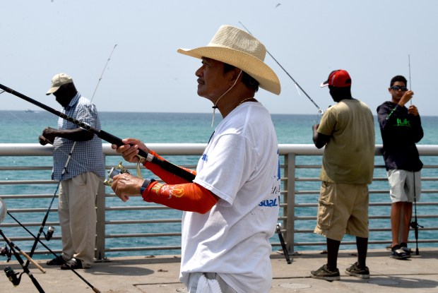 Fisherman Alex DeCastro and others fish off of Boynton Beach Inlet Tuesday.