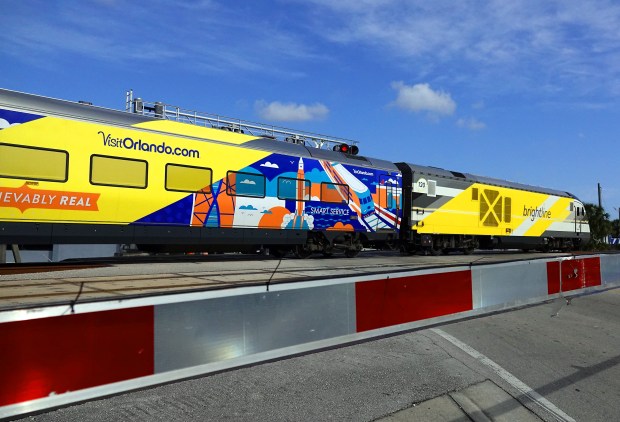 A Brightline train speeds past a railroad crossing on Andrews Ave in Fort Lauderdale, Thursday, March 14, 2024. (Joe Cavaretta/South Florida Sun Sentinel)