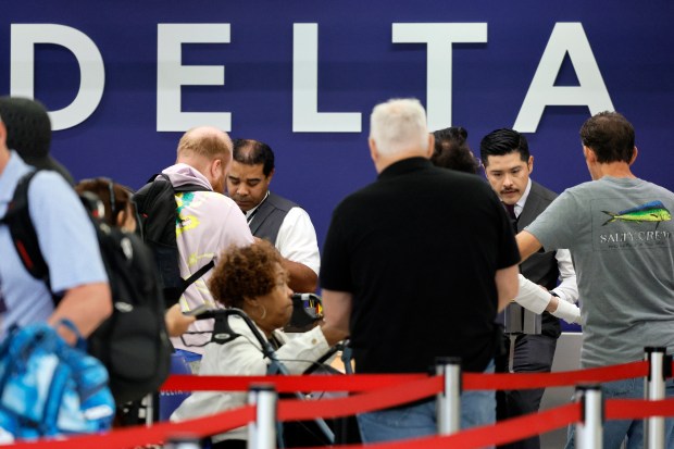 Employees assist travelers at the Delta ticket counter at Fort Lauderdale-Hollywood International Airport on Friday, July 19, 2024. A Microsoft 365 update affected users of the cybersecurity firm CrowdStrike, causing massive outages and delays at airports worldwide. (Amy Beth Bennett / Sun Sentinel)