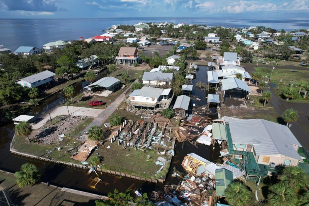 FILE - An empty lot, left, is all that remains where the two-bedroom vacation home that retired pipe fitter Charles Long had been fixing up to live in full time with his wife once stood, in Horseshoe Beach, Fla., Thursday, Aug. 31, 2023, one day after the passage of Hurricane Idalia. As the 2024 hurricane season began in June, Long's vision for his retired life in Horseshoe had been forced to shift, and he was putting the finishing touches on a pole barn and utility hookups to be ready for the camper he was saving up to buy. (AP Photo/Rebecca Blackwell, File)