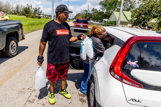 Pastor Tony O. Graham hands out bags of ice along with Rebecca Baker, a volunteer with Cajun Navy from Louisiana, in Perry, Fla., on Thursday, Aug. 31, 2023. Taylor County felt the full impacts of Hurricane Idalia, which made landfall near Category 4 strength on Wednesday morning. (Patrick Connolly/Orlando Sentinel)