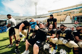 UCF offensive line coach Herb Hand breaks down a play to his offensive line on a Microsoft Surface tablet during the Knights' scrimmage on Saturday. (Courtesy of UCF Athletics)